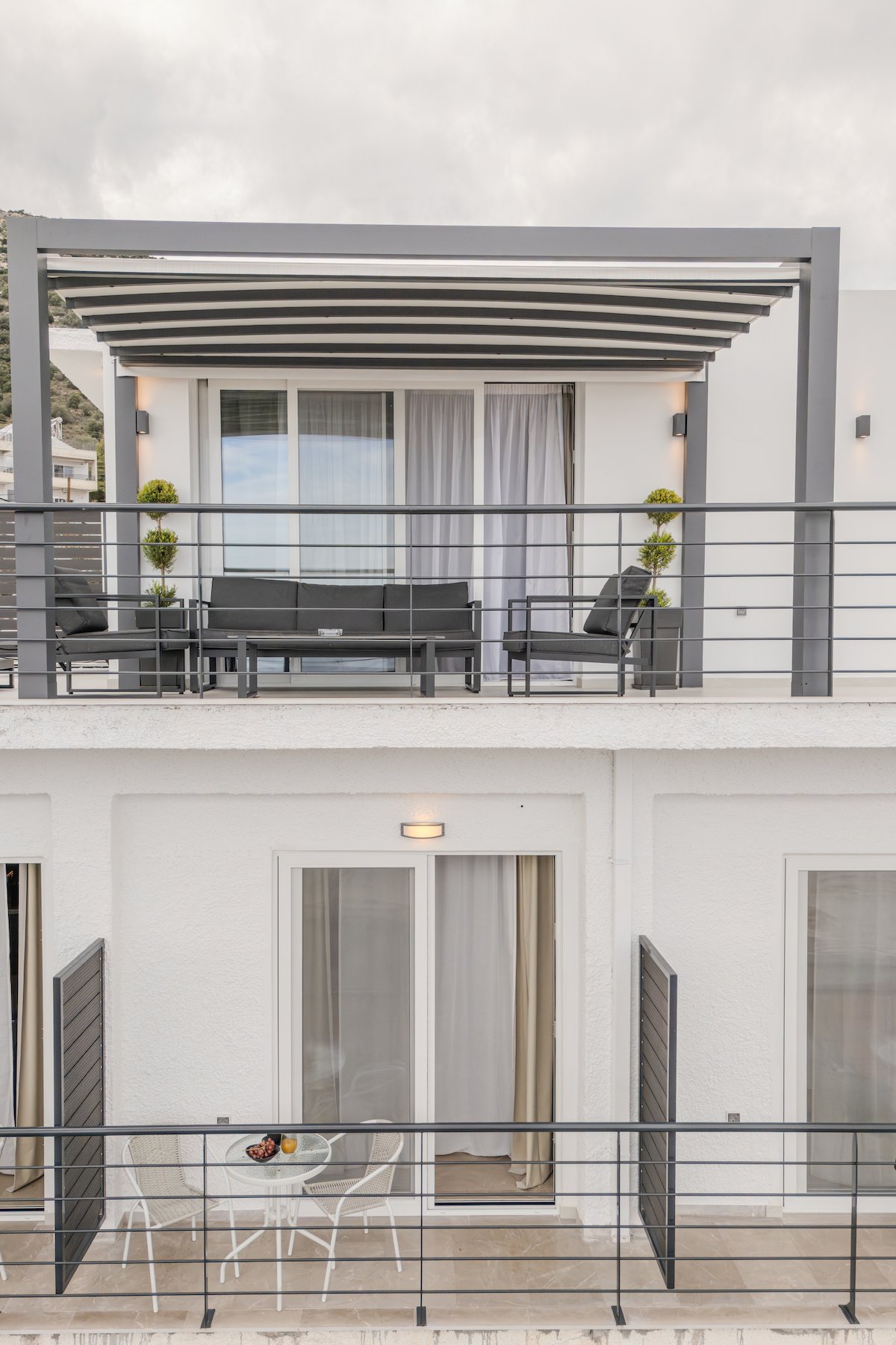 A sun-drenched Mediterranean patio with comfortable seating and potted plants at Noma Suites Tolo.